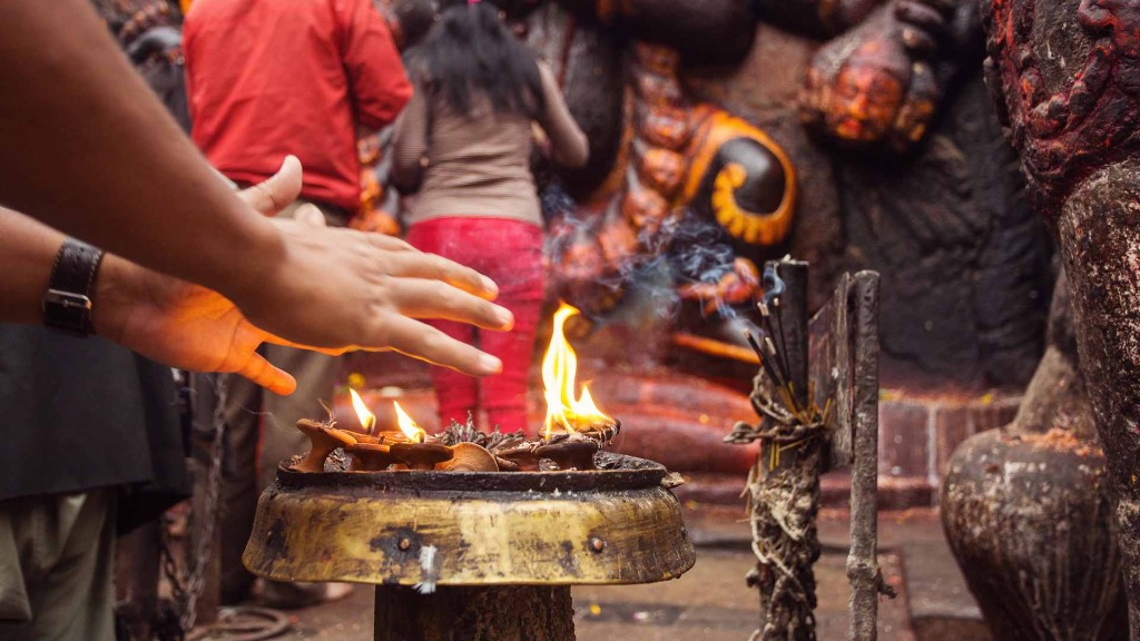 Traditional dawn ritual ceremony with Nepali priests at sacred river in Kathmandu